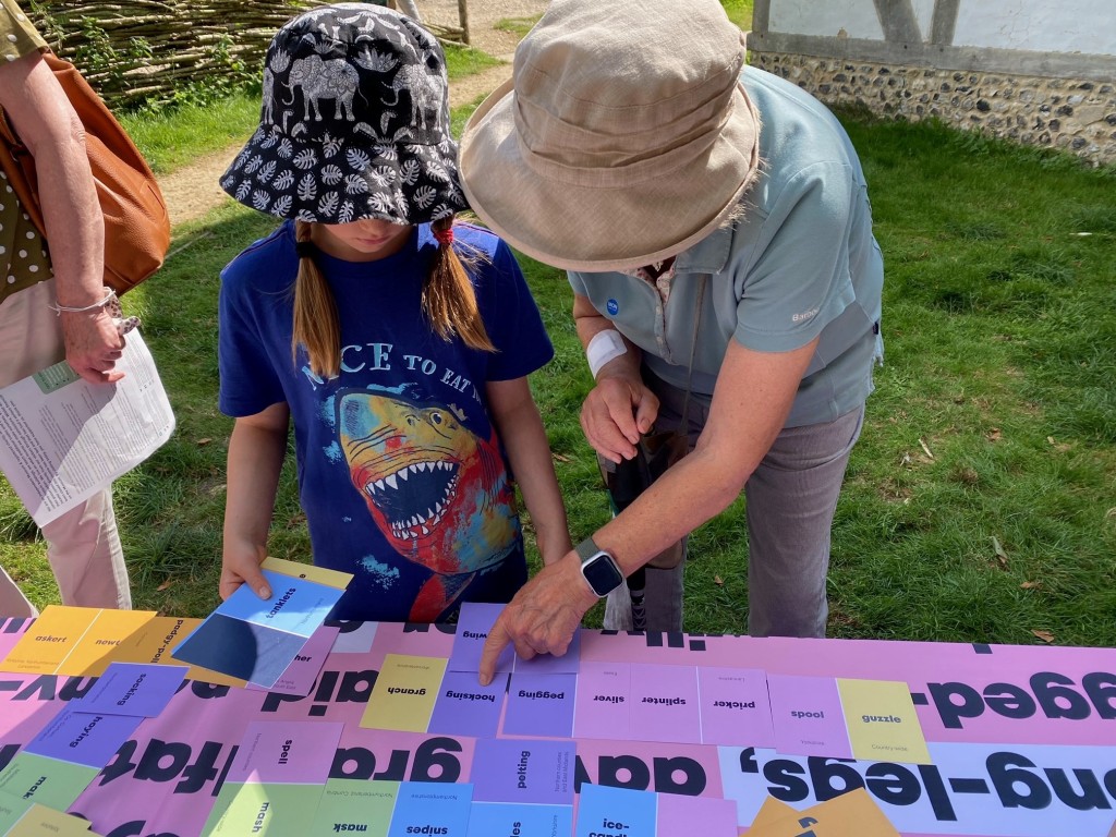 A young girl and her grandmother play a game to match pairs of dialect words.